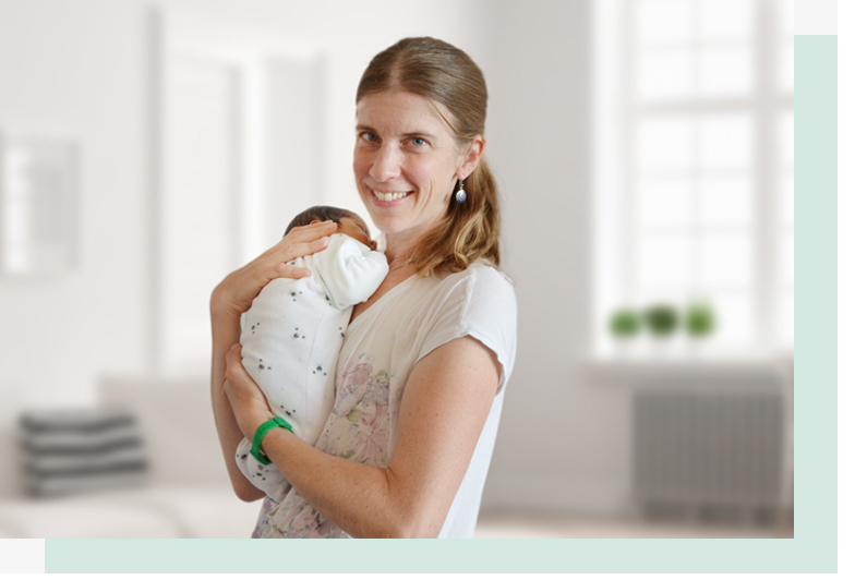 Doula Barbara Schipp mit einem Neugeborenen im Arm